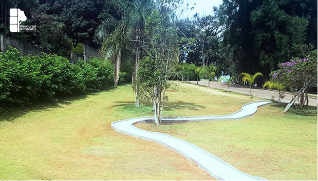 Família sentada em banco de jardim cercado por natureza em espaço de contemplação